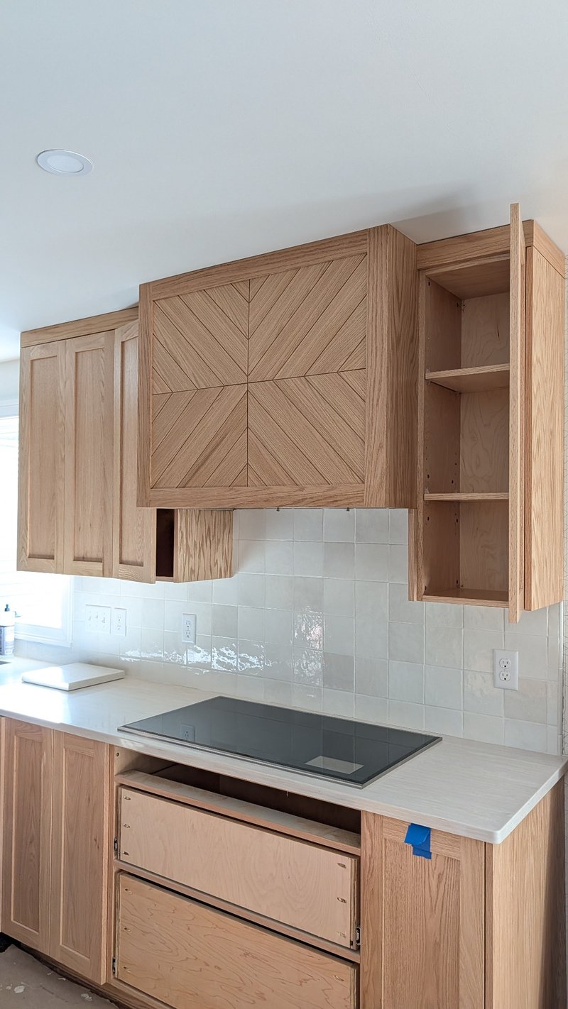 Red oak range hood panel with a geometric pattern and visible grain directions.
