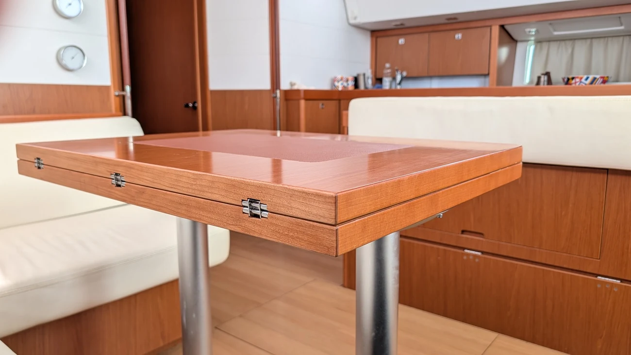Close view of the folded tabletop, showing its paired edges and three hinges above the existing metal legs.